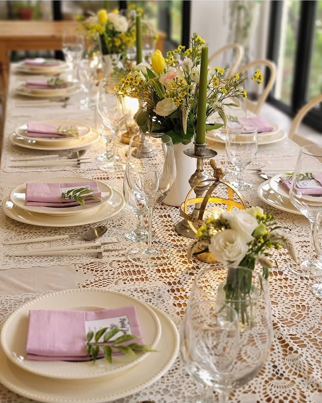 Intimate table setting with lace tablecloth, pink napkins and florals